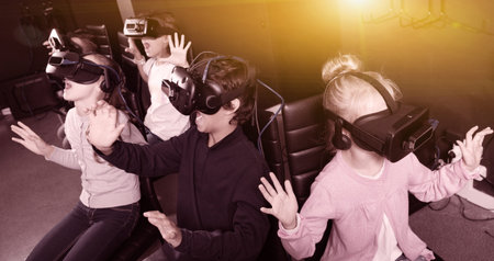Enthusiastic happy positive  children in virtual reality glasses in quest room