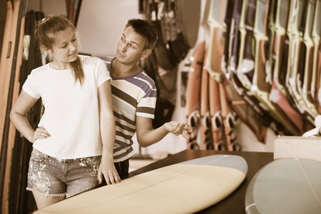 Young couple choosing surfboard in store in time summer holidaysの写真素材
