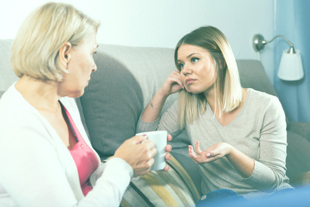 Adult daughter and her mother discussing something at home

の写真素材