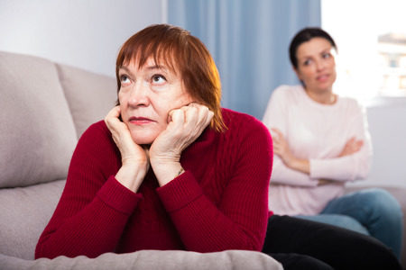 Unhappy women sitting at sofa after conflict at home interior
の写真素材