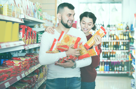 Positive young family selecting pasta at grocery store
 の写真素材