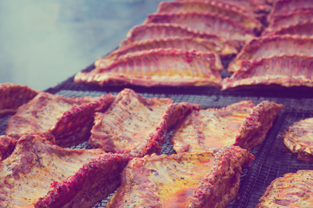 Ruddy pork ribs with a crust of fresh meat lying on the grillの写真素材