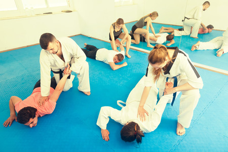 Young russian trainees sparring in pairs to practice new holds in taekwondo classの写真素材