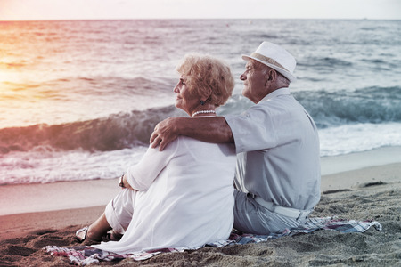 mature man and woman sitting back and hugging on the sea shore
の写真素材