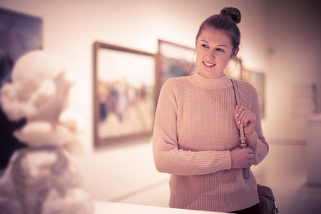 Portrait of young woman visitor standing in art museum of ancient sculptureの写真素材