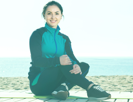 Young spanish woman ready to start morning training on beachの写真素材