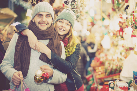 Happy girl with boy in hat delighted with purchases at  Christmas marketの写真素材