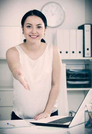 Smiling woman manager waiting for clients in officeの写真素材