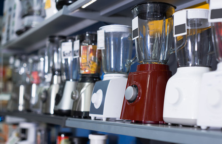 Shelves with versatile blenders, juicers and other electronics kitchen domestic machines at storeの写真素材