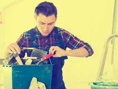 Handyman searching in his toolbox for necessary toolsの写真素材