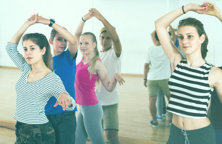 Group of positive american teen dancing salsa in dance studio