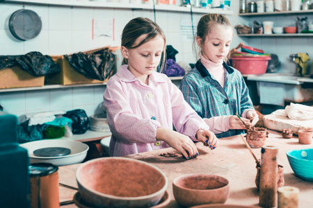 Female teenagers practicing their skills at making pottery during arts and crafts class