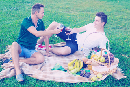 
male with a friend enjoying life on picnic outdoors in male companyの写真素材
