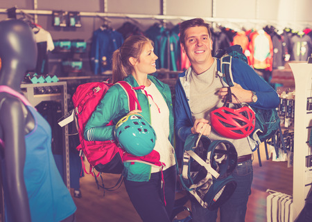 Young couple demonstrates the selected travel gear in sports shopの写真素材