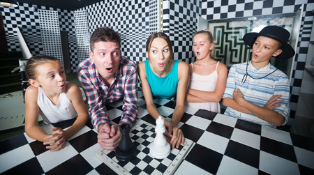 Young family is visiting of escaperoom stylized under chessboardの写真素材