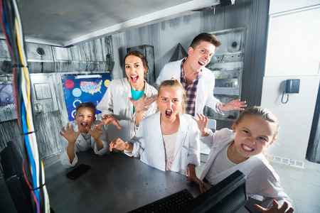 Happy positive  family of five is depisting madness in time having fun together in lost labroom.の写真素材