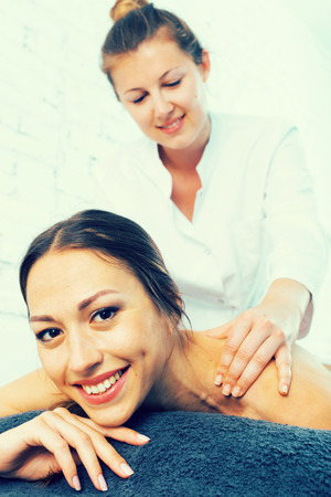 Relaxing woman getting back massage in spa centerの写真素材