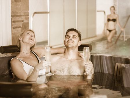 Romantic couple is relaxing with glasses of vine in spa-salon.の写真素材