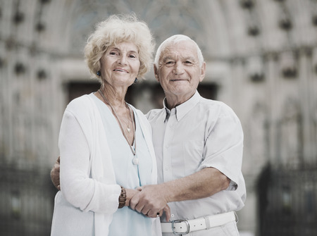 Close up of romantic happy cheerful positive  senior couple on city streets on joint vacationの写真素材