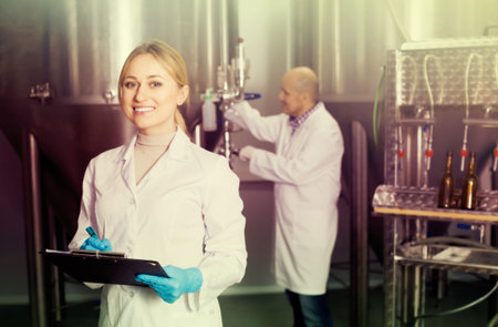 Portrait of smiling woman employee in modern beer production facility