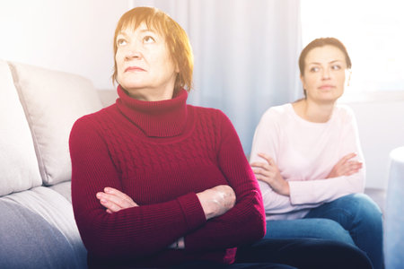 Portrait upset adult women looking away after conflict at home interiorの写真素材
