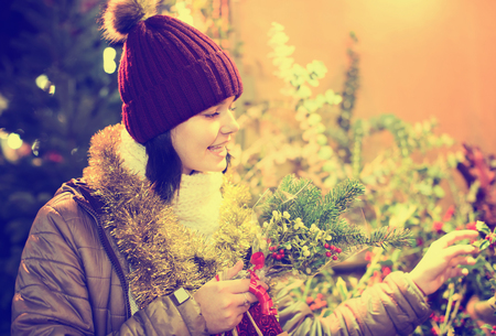  Young teen girl staying near counter with floral composition at Xmas fair の写真素材