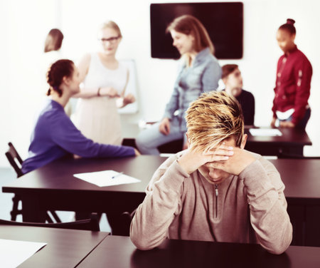 New male student feeling shy at recess during school dayの写真素材