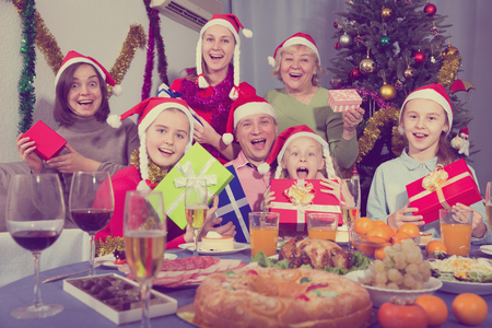 Portrait of happy family who is sitting with gifts in time celebrating New Year at home.の写真素材