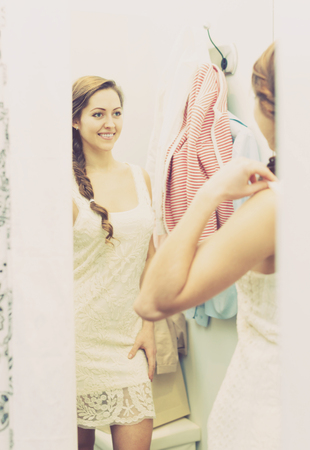 Portrait of happy female with new garment at fitting-roomの写真素材