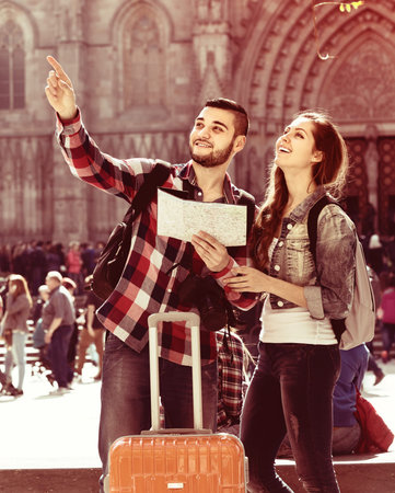 Happy young tourist couple with map in the cityの写真素材