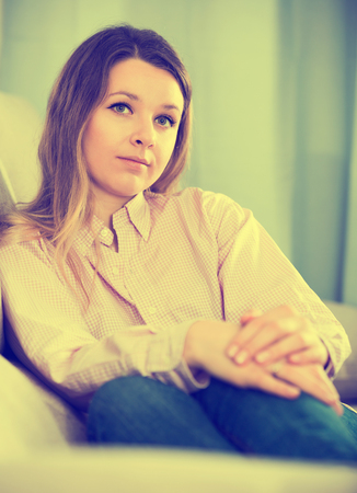 Young female feeling and spending day alone at homeの写真素材