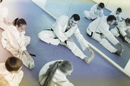 Smiling children getting ready and stretching for karate classの写真素材
