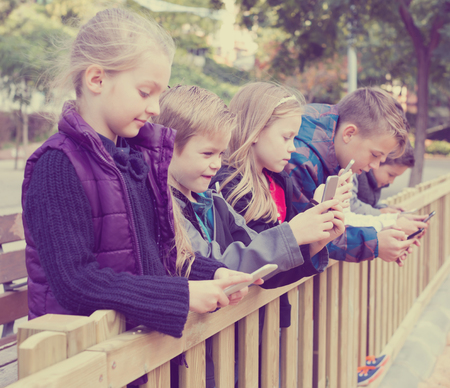 Children played smartphones in streetの写真素材