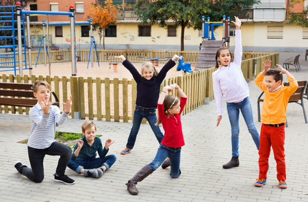 Acting game with happy cheerful positive children making performance outdoor in autumnの写真素材