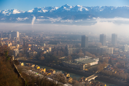 Aerial view of Grenoble against backdrop of snowy Alps in sunny day, Franceの写真素材