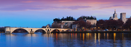 View of four surviving arches of Pont St-Benezet and Avignon Cathedral at sunset, Franceの写真素材