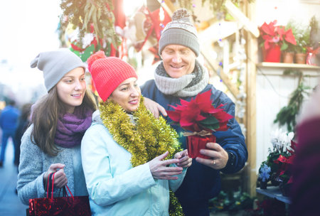 middle-aged parents with teenage girl at counter with Poinsettia and  floral decorations at the fairの写真素材