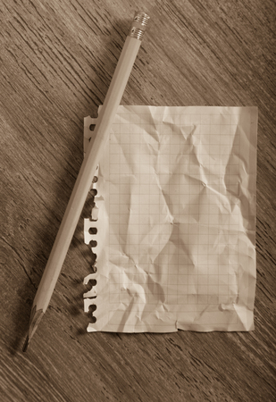 Empty crumpled page torn from notebook lying on wooden surfaceの写真素材
