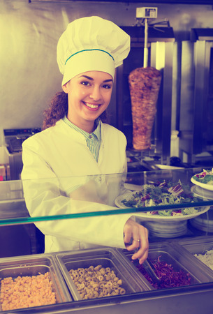 Portrait of friendly female with traditional kebab at fastfood placeの写真素材