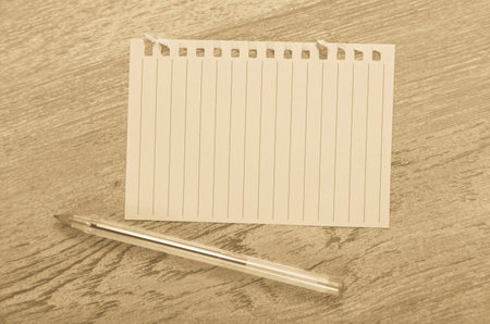 Empty page torn from notebook lying on wooden surface