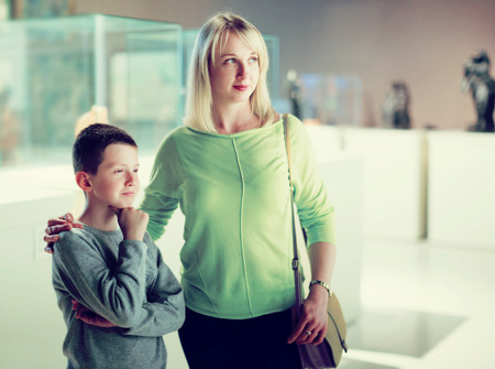 Young mother and son exploring expositions in museumの写真素材
