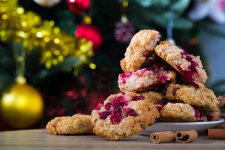 Plate of homemade oat cookies on wooden table with cinnamon sticks in Christmas decorationの写真素材