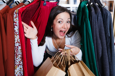 Positive cute girl customer delighted between the handles in the  storeの写真素材