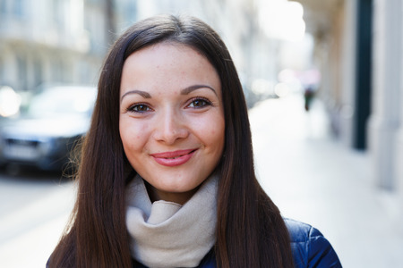 Portrait of young smiling woman in jacket in the historical city centerの写真素材