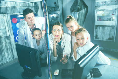 Cheerful positive  family of five is using PC in time having fun together in lost labroom.の写真素材