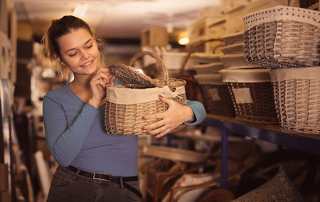 Beautiful female with picnic wicker basket in furniture storeの写真素材