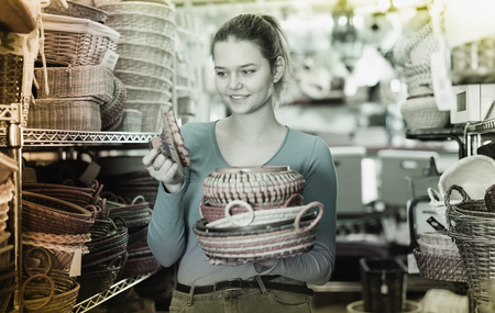 girl customer  with multicolor wicker basket in decor items storeの写真素材