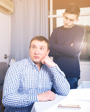 Man is offended and son is not wanting talking with him at the home.の写真素材