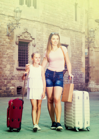 
Young woman and daughter walk around the European city with luggageの写真素材
