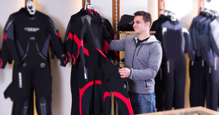  positive male is standing with costume for diving in the store.の写真素材